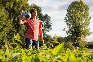 JEUNE ADOLESCENT QUI CHANTE ET ECOUTE DE LA MUSIQUE DANS LA NATURE, RUGLES (27), FRANCE 