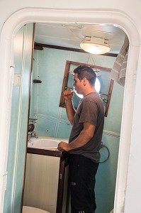 NIZAR DANS LA CABINE DE TOILETTES, PECHE EN MER SUR UN CHALUTIER A LA LANGOUSTINE 'LE QUENTIN-GREGOIRE' AU LARGE DES SABLES-D'OLONNE (85), FRANCE 