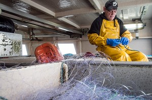 MARIN A LA REPARATION DU FILET, PECHE EN MER SUR LE FILEYEUR 'LES OCEANES' AU LARGE DE LORIENT (56), BRETAGNE, FRANCE 