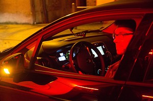 JEUNE HOMME AU VOLANT DE SA VOITURE A LA SORTIE DU CAFE (CAPITAINE DE SOIREE), CHAUFFEUR QUI ATTEND SES AMIS POUR LES RAMENER A LA MAISON, FRANCE 