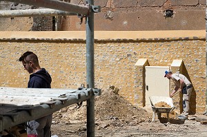 OUVRIERS SUR UN CHANTIER DE RESTAURATION D'UN MUR ANCIEN EN PIERRE ET CHAUX OCRE, THIRON-GARDAIS (28), FRANCE 