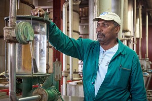 OUVRIER A LA PRODUCTION POUR MESURER LE TAUX D'ALCOOL EN SORTIE D'ALAMBIC, DISTILLERIE MARTINIQUAISE DE RHUM DES PLANTATIONS SAINT-JAMES, SAINTE-MARIE, MARTINIQUE, ANTILLES FRANCAISES, FRANCE 