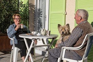 COUPLE DE PERSONNES AGEES AVEC LEUR CHIEN SUR LA TERRASSE  DE LA MAISON, VILLE DE VERNEUIL-SUR-AVRE (27), FRANCE 