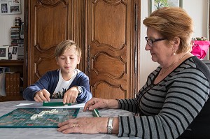GRAND-MERE AVEC SON  PETIT-FILS EN TRAIN DE JOUER AU SCRABBLE, VILLE DE VERNEUIL-SUR-AVRE (27), FRANCE 