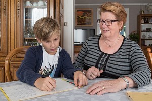 GRAND-MERE AVEC SON PETIT-FILS EN TRAIN DE FAIRE LES DEVOIRS D'ECOLE LA MAISON, VILLE DE VERNEUIL-SUR-AVRE (27), FRANCE 