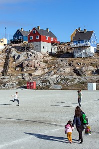 ENFANTS SUR LE TERRAIN DE FOOTBALL DEVANT LES MAISONS COLOREES, ILULISSAT, GROENLAND 