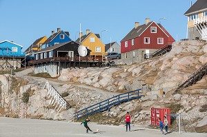 ENFANTS SUR LE TERRAIN DE FOOTBALL DEVANT LES MAISONS COLOREES, ILULISSAT, GROENLAND 