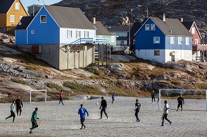 HOMMES ADULTES SUR LE TERRAIN DE FOOTBALL DEVANT LES MAISONS COLOREES, ILULISSAT, GROENLAND 
