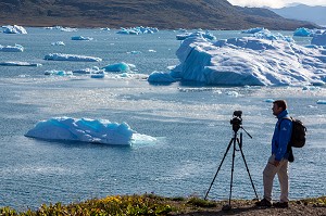 CAMERAMAN FILMANT LE SPECTACLE OFFERT PAR LES ICEBERGS FLOTTANT DANS LE FJORD DE LA BAIE DE NARSAQ, GROENLAND 