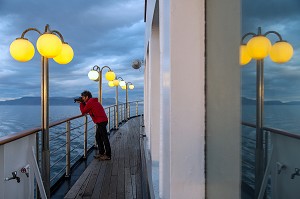 PHOTOGRAPHE SUR LE PONT SUPERIEUR DU PAQUEBOT, BATEAU DE CROISIERE ASTORIA DEVANT LES COTES ISLANDAISES, ISLANDE 