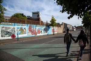 COUPLE EN PROMENADE DEVANT LE MUR DE LA PAIX DE SHANKILL ROAD, SOUVENIRS DES EMEUTES DU CONFLIT NORD IRLANDAIS, NORTHUMBERLAND STREET, BELFAST, ULSTER, IRLANDE DU NORD 