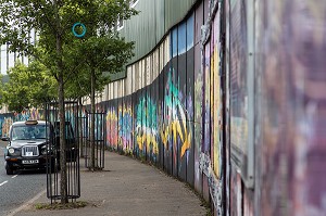 TAXI IRLANDAIS DEVANT LES FRESQUES MURALES SUR LE MUR DE LA PAIX (PEACE LINE) SEPARANT LE QUARTIER PROTESTANT SHANKILL DE FALLS CATHOLIQUE, SPRINGMARTIN ROAD, QUARTIER OUEST, BELFAST, ULSTER, IRLANDE DU NORD 