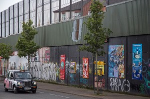 TAXI IRLANDAIS DEVANT LES FRESQUES MURALES SUR LE MUR DE LA PAIX (PEACE LINE) SEPARANT LE QUARTIER PROTESTANT SHANKILL DE FALLS CATHOLIQUE, SPRINGMARTIN ROAD, QUARTIER OUEST, BELFAST, ULSTER, IRLANDE DU NORD 