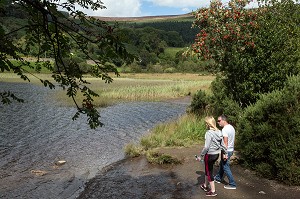 COUPLE EN PROMENADE SUR LES BORDS DU LAC LOWER LAKE, SITE DES RUINES DE L'ANCIEN MONASTERE DE GLENDALOUGH, COMTE DE WICKLOW, IRLANDE 