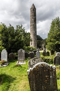 PIERRES TOMBALES DEVANT LA TOUR RONDE HAUTE DE 33 METRES RUINES DE L'ANCIEN MONASTERE DE GLENDALOUGH ETABLI AU VI EME SIECLE DETRUIT EN 1398 PAR LES ANGLAIS, COMTE DE WICKLOW, IRLANDE 