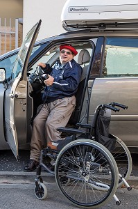 HOMME HANDICAPE PHYSIQUE DANS SON FAUTEUIL ROULANT DEVANT SA VOITURE ADAPTEE, CHARTRES (28), FRANCE 