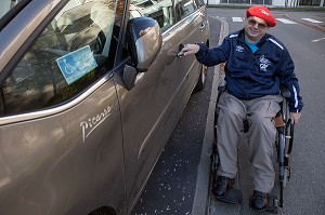 HOMME HANDICAPE PHYSIQUE DANS SON FAUTEUIL ROULANT A LA PORTIERE DE SA VOITURE ADAPTEE, CHARTRES (28), FRANCE 