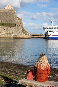 FEMME ASSISE, FORTERESSE VAUBAN DEVANT LE PORT, LE PALAIS, MORBIHAN (56), FRANCE 