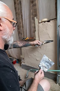 OUVRIER SUR UN CHANTIER DE RESTAURATION, (COLLE, CIMENT, MAP), TRAVAUX D'AMENAGEMENT INTERIEUR, RENOVATION D'UNE MAISON 