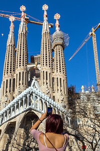 FEMME PHOTOGRAPHIANT LA FACADE BASILIQUE LA SAGRADA FAMILIA AVEC SON SMARTPHONE, TEMPLE EXPIATORI, BARCELONE, CATALOGNE, ESPAGNE 