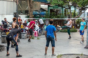 JEUNES JOUANT AU SEPAK TAKRAW, SORTE DE VOLLEY BALL AVEC LE PIED, SPORT NATIONAL DU PAYS, DANS LES RUES DE LA VILLE DE BANGKOK, THAILANDE 