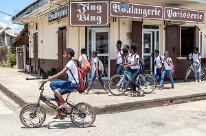 ECOLIERS TOUS HABILLES AUX MEMES COULEURS DEVANT UNE BOULANGERIE, SCENE DE RUE, SAINT-LAURENT DU MARONI, GUYANE FRANCAISE, DEPARTEMENT-REGION D'OUTRE-MER, AMERIQUE DU SUD, FRANCE 