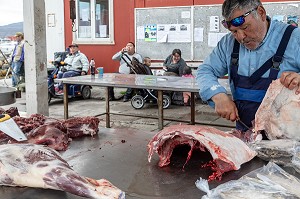 BOUCHER DECOUPANT DES CARCASSES DE BOEUF MUSQUE AU MARCHE AU VIANDE, VILLE DE QAQORTOQ, GROENLAND, DANEMARK 