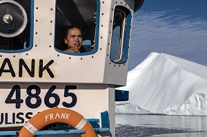 PECHEUR SUR LE BATEAU LE FRANCK ET EN ARRIERE PLAN UN ICEBERG, ILULISSAT, GROENLAND, DANEMARK 