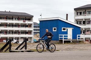 HOMME A VELO DEVANT DES CITES HLM, SISIMIUT, GROENLAND, DANEMARK 