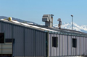 COUVREUR SUR UN TOIT EN TRAIN DE POSER UN ISOLANT, CHAMBERY, SAVOIE (73), FRANCE 