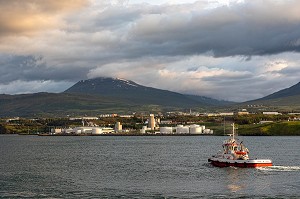 BATEAU PILOTE DEVANT LE PORT COMMERCIAL AVEC LES CUVES SE STOCKAGE DE CARBURANT, ZONE PORTUAIRE, AKUREYRI, ISLANDE, EUROPE 