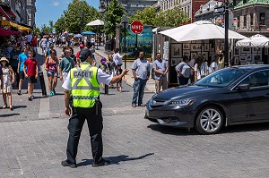 JEUNE CADET DE LA POLICE AFFECTE A LA CIRCULATION, REGULATION DU TRAFIC DES VOITURES, RUE DE LA COMMUNE, MONTREAL, QUEBEC, CANADA