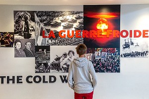 ADOLESCENT REGARDANT LE PANNEAU RETRACANT LES MOMENTS FORTS IMPORTANTS DE LA GUERRE FROIDE, EXPOSITION SUR LES MUR DU MEMORIAL DE CAEN, CALVADOS (14), NORMANDIE, FRANCE 