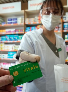 ECHANGE DE LA CARTE VITALE ENTRE LE CLIENT ET LA PHARMACIENNE, MESURES SANITAIRES DE PREVENTION SUITE A L'EPIDEMIE DE CORONAVIRUS, PHARMACIE DE RUGLES, NORMANDY, FRANCE 