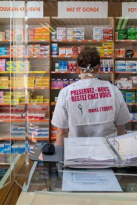 PRESERVEZ-NOUS, RESTEZ CHEZ VOUS, EMPLOYE DE LA PHARMACIE DERRIERE DES VITRES DE PROTECTION EN PLEXIGLASS, MESURES SANITAIRES DE PREVENTION SUITE A L'EPIDEMIE DE CORONAVIRUS, RUGLES, NORMANDIE, FRANCE 