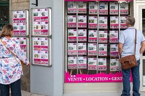 PASSANTS DEVANT LES VITRINES D'ANNONCES IMMOBILIERES, AGENCE IMMOBILIER LOCATION, VENTE ET GESTION, AUBUSSON, CREUSE, FRANCE 