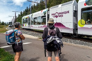 RANDONNEURS A PIED DEVANT LE TRAIN PANORAMIQUE DES DOMES VERS LE SOMMET DU PUY-DE-DOME, VOLCAN D'AUVERGNE, ORCINES, FRANCE 