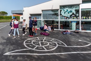 ELEVES ET MAITRESSE DANS LA COUR DE RECREATION, MARELLE EN FORME D'ESCARGOT, ECOLE ELEMENTAIRE, TONNAY-BOUTONNE, CHARENTE-MARITIME (17), FRANCE 