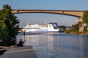 PECHEUR DEVANT LE BATEAU DE BRITTANY FERRIES SOUS LE VIADUC DE CALIX AU DESSUS DU CANAL DE CAEN A LA MER, RIVIERE L'ORNE, CAEN, CALVADOS, NORMANDIE, FRANCE 