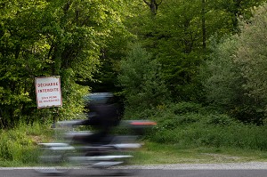 MOTO DEVANT LA FORET AVEC UN PANNEAU DE DECHARGE INTERDITE SOUS PEINE DE POURSUITES, RUGLES, EURE, NORMANDIE, FRANCE 