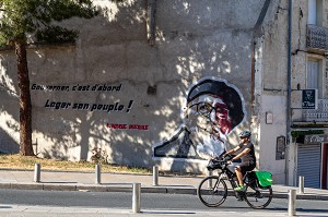 VELO DEVANT LA PEINTURE MURALE DE L'ABBE PIERRE, GOUVERNER, C'EST D'ABORD LOGER SON PEUPLE, RUE DU FAUBOURG DE NIMES, MONTPELLIER, HERAULT, OCCITANIE, FRANCE 