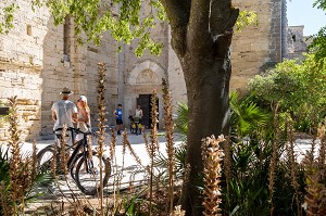 COUPLE A VELO DEVANT L'ENTREE DE LA CATHEDRALE DE MAGUELONE, EGLISE INSULAIRE RESTAUREE, VILLENEUVE-LES MAGUELONE, HERAULT, OCCITANIE, FRANCE 