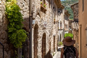 FEMME AU CHAPEAU DE PAILLE, PETITE RUELLE DU VILLAGE, CLASSE PLUS BEAU VILLAGE DE FRANCE, SAINT-GUILHEM-LE-DESERT, HERAULT, OCCITANIE, FRANCE 