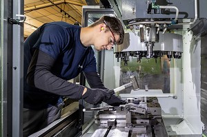 OUVRIER QUI INSTALLE UN PIECE SUR SA MACHINE, USINAGE DE PIECES METALLIQUE, SMA, SOCIETE MECANIQUE AIGLONNE, INDUSTRIE METALLURGIQUE, SAINT-MARTIN-D'ECUBLEI, ORNE, NORMANDIE, FRANCE 