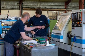 OUVRIER AVEC SON APPRENTI POUR TRANSMISSION DES INSTRUCTION ET FORMATION SUR LA MACHINE, SMA, SOCIETE MECANIQUE AIGLONNE, INDUSTRIE METALLURGIQUE, SAINT-MARTIN-D'ECUBLEI, ORNE, NORMANDIE, FRANCE 