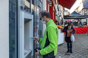 RESIDENT AUTONOME AU DISTRIBUTEUR DE BILLETS AVEC SA CARTE BLEUE, FOYER D'HEBERGEMENT POUR ADULTES EN SITUATION DE HANDICAP INTELLECTUEL, RESIDENCE LA CHARENTONNE, ADAPEI27, ASSOCIATION DEPARTEMENTALE D'AMIS ET DE PARENTS, BERNAY, EURE, NORMANDIE, FRANCE 