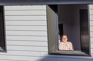 RESIDENTE A LA FENETRE DE SA CHAMBRE INDIVIDUELLE, FOYER D'HEBERGEMENT POUR ADULTES EN SITUATION DE HANDICAP INTELLECTUEL, RESIDENCE LA CHARENTONNE, ADAPEI27, ASSOCIATION DEPARTEMENTALE D'AMIS ET DE PARENTS, BERNAY, EURE, NORMANDIE, FRANCE 