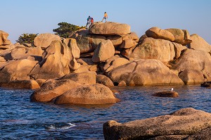 TOURISTES EN FAMILLE SUR LES ROCHERS DE GRANITE, POINTE DE L'ILE RENOTE, TREGASTEL, COTE DE GRANIT ROSE, COTES-D’ARMOR, BRETAGNE, FRANCE 