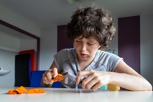 SEANCE D'ERGOTHERAPIE AVEC UN RESIDENT POUR APPRENDRE A TENIR SES COUVERTS A TABLE, SESSAD LA RENCONTRE, ACCUEIL DE JOUR, ORGANISME DE SOUTIEN ET DE SERVICES AUX PERSONNES HANDICAPEES, LE NEUBOURG, EURE, NORMANDIE, FRANCE 