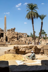 HOMME QUI TRAVAILLE A TAMISER LE SABLE EN PLEIN SOLEIL, RUINES ET OBELISQUE, DOMAINE D'AMON, TEMPLE DE KARNAK, SITE DE L'EGYPTE ANTIQUE DE LA XIII EME DYNASTIE, PATRIMOINE MONDIAL DE L'UNESCO, LOUXOR, EGYPTE, AFRIQUE 